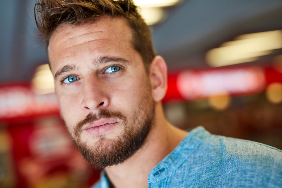 Young man with a slight beard, gazing beyond the camera.