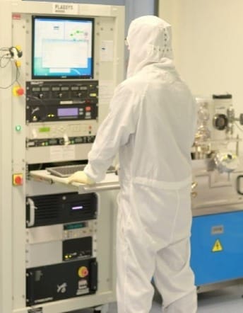 A cleanroom technician monitors semiconductor fabrication equipment, highlighting how traceable manufacturing steps become invisible once supply chains move into shadow channels..