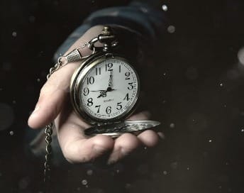a person holding a clock in their hand