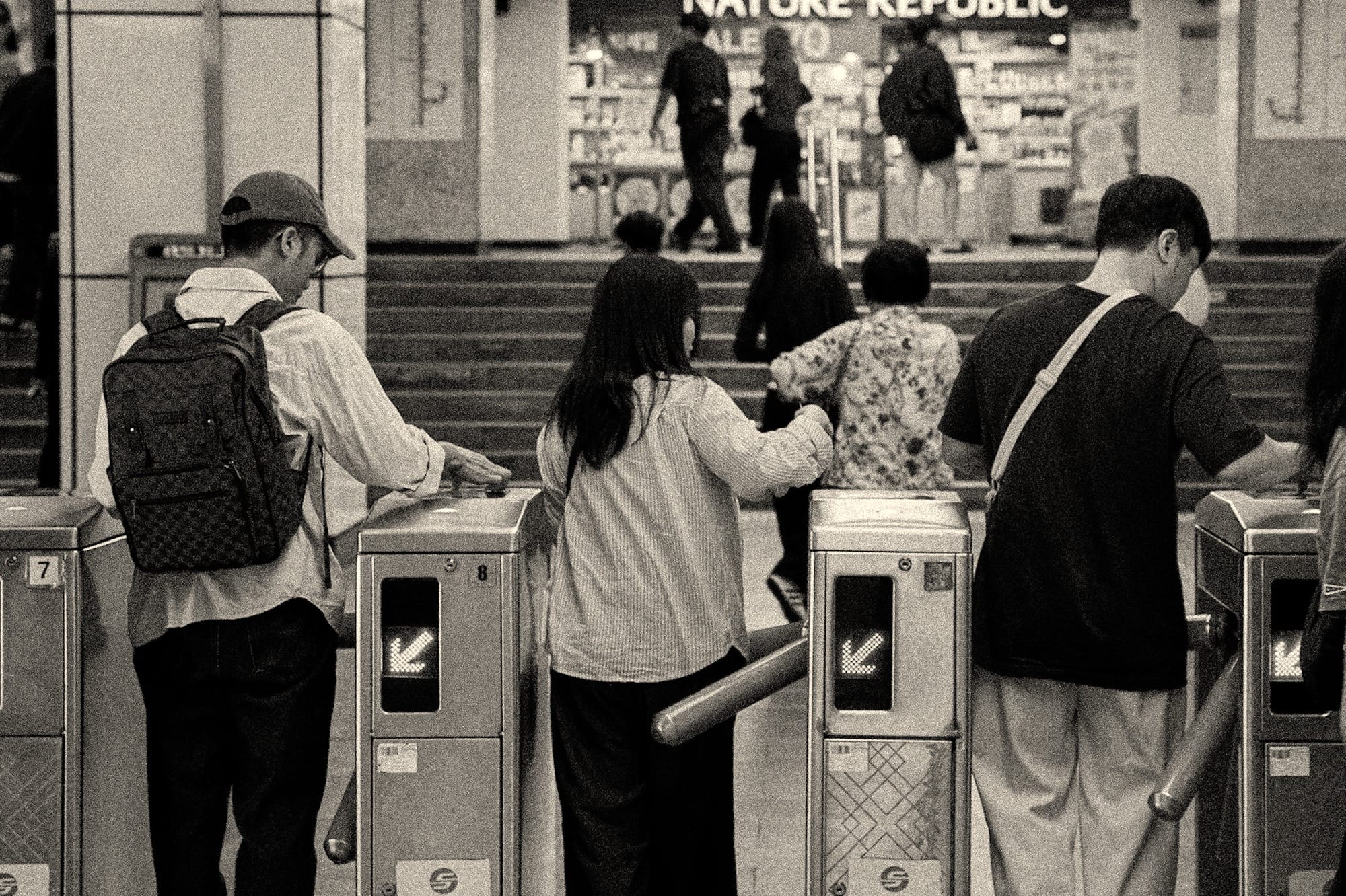 People passing through subway turnstiles.