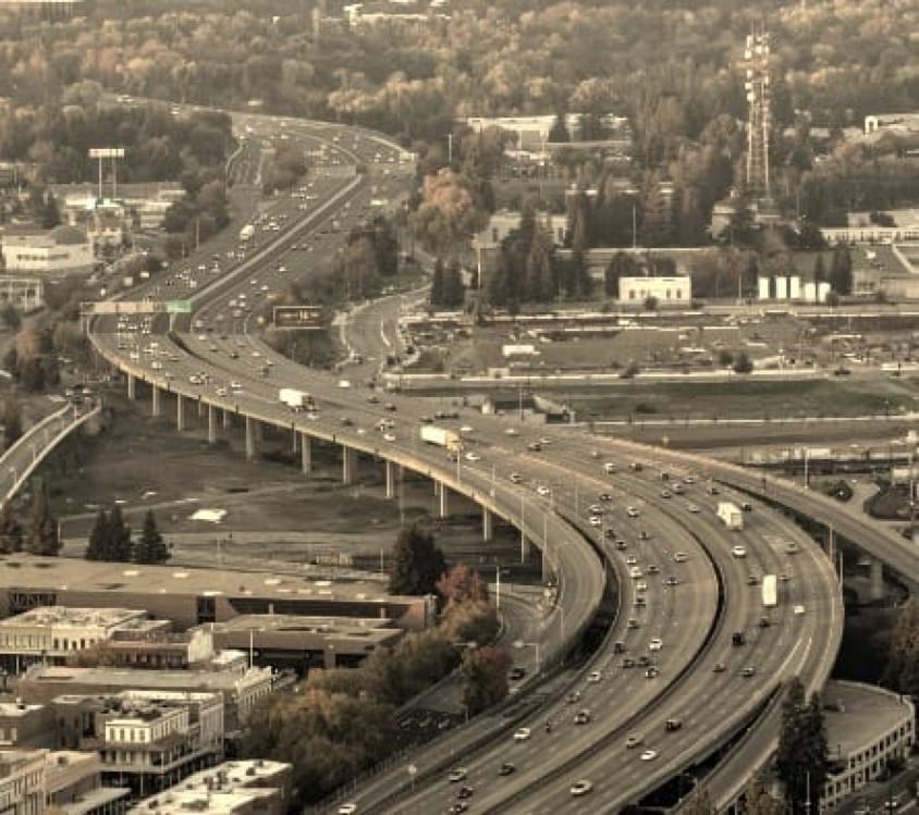 Busy highway interchange with traffic at sunset.