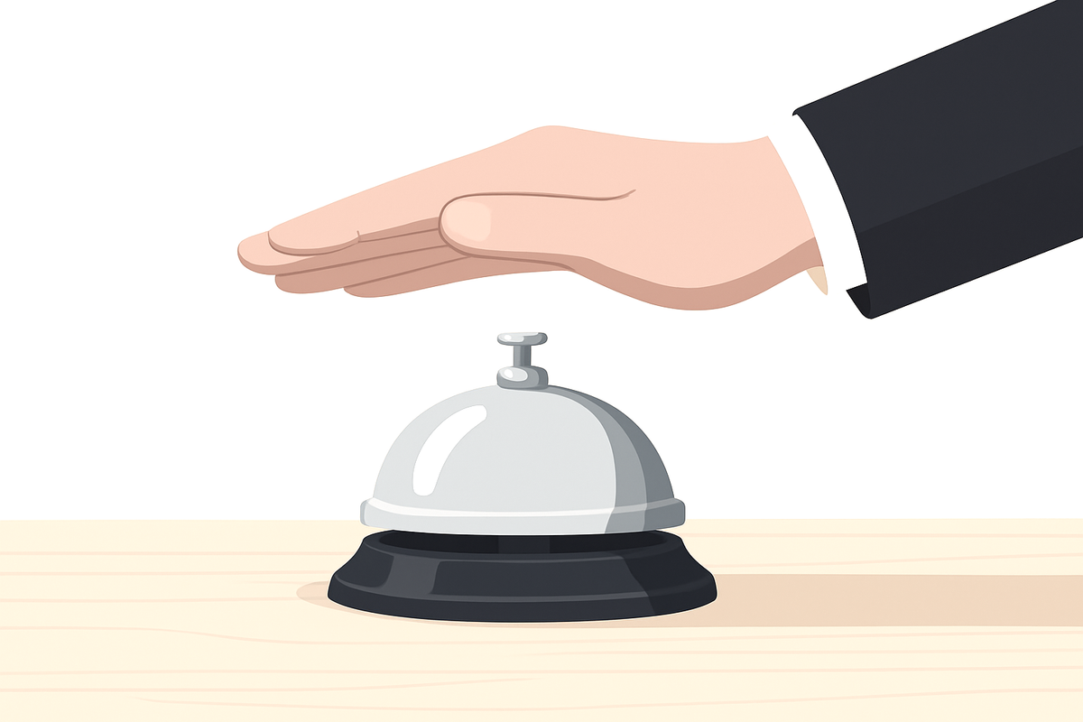 Hand hovering over a silver service bell on a desk, symbolizing a moment of decision at the point of entry into a service system.