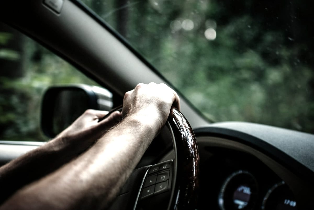 A driver’s hands on the wheel, sensing the world beyond the glass. Cooperation begins here.
