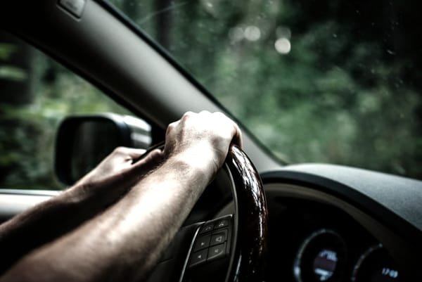 A driver’s hands on the wheel, sensing the world beyond the glass. Cooperation begins here.