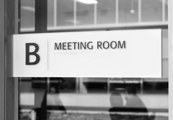 A sign which says Meeting Room B, with the letter B on the left side.