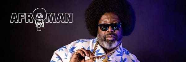 Afroman in sunglasses and a blue-and-white patterned shirt, posed against a dark background in a promotional profile image.